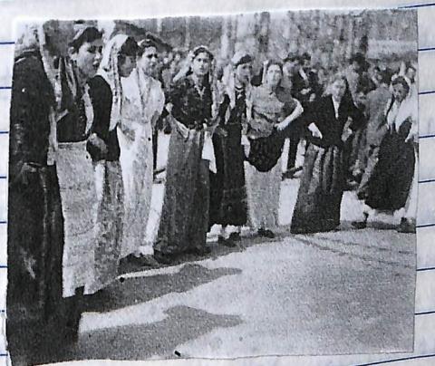 Γυναίκες με διάφορες παραδοσικές ενδυμασίες που κρατούν τα χέρια και χορεύουν. Ασπρόμαυρη φωτογραφία