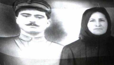 Εικόνα που απεικονίζει έναν άντρα και μία γυναίκα. Ο άντρας φοράει καπέλο και στολή, η γυναίκα είναι μαυροφορεμένη με μαντίλι στο κεφάλι.