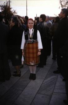 Γκελίνκα. Η παραδοσιακή στολή των γυναικών, που την βρίσκουμε και στον πολιτιστικό σύλλογο. Ν εαρό κορίτσι φοράει την παραδοσιακή στολή του τόπου της. Η φορεσιά περιλαμβάνει λευκό πουκάμισο, μαύρο γιλέκο. Η η φούστα είναι σε πορτοκαλί καρό χρώμα. Μαύρα παπούτσια και κόκκινο τσεμπέρι.